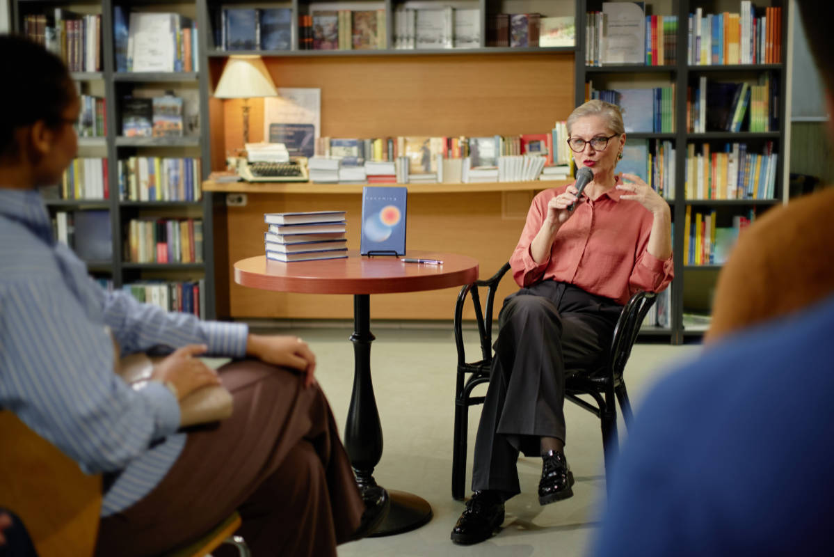 A woman proudly shows her published book